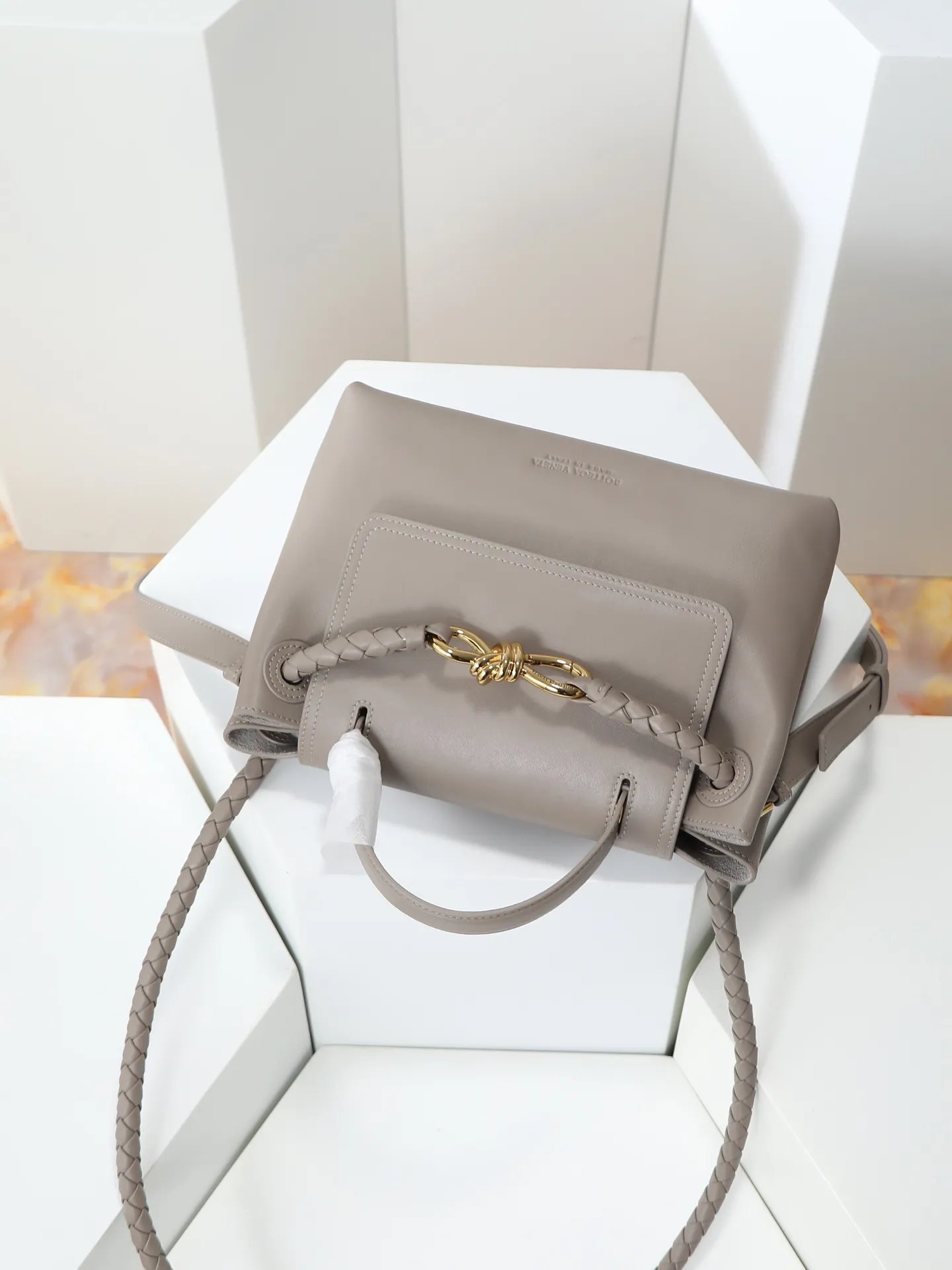 1150. Bottega Veneta's latest Ciao Ciao bag is a two-way flap handbag in silky cowhide, decorated with signature twist details, hidden hook closure, the flap can be fastened to the front, or connected to the INTRECCIATO woven internal pocket, with an adjustable and removable crossbody strap, an internal compartment, and a zippered pocket. The surprise flap has various shapes. Style 1 - Cover the bag surface, exposing the knot and knot decoration. Style 2 - Place the flap inside the bag. A buckle is also designed. Style 3 - The U-shaped position of the top handle in the hand bag. Style No.: 835835 Size: 26*19*10.5cm